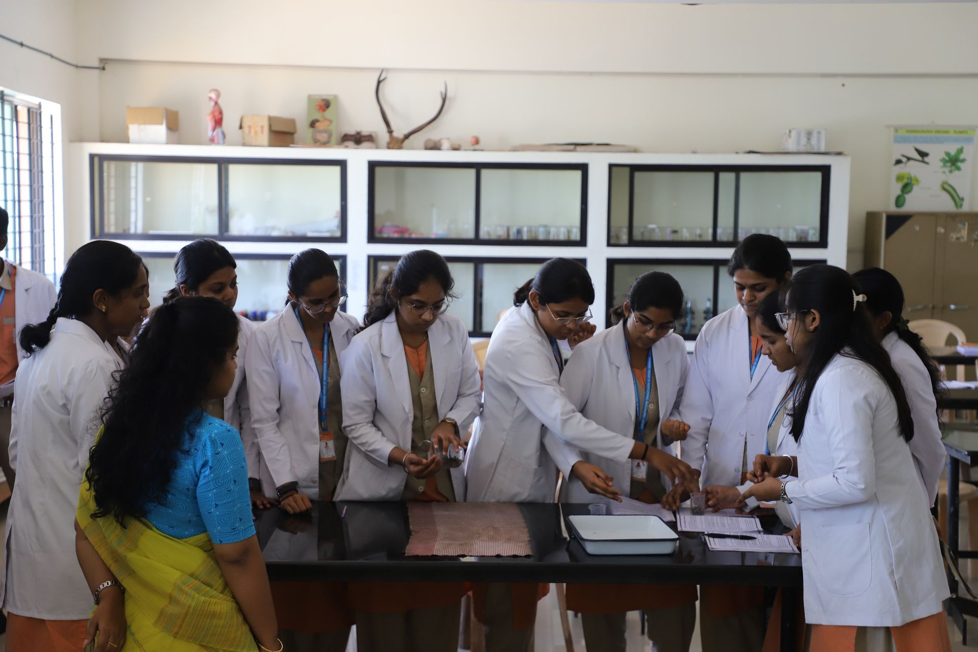 Teacher guiding students during a lab practical